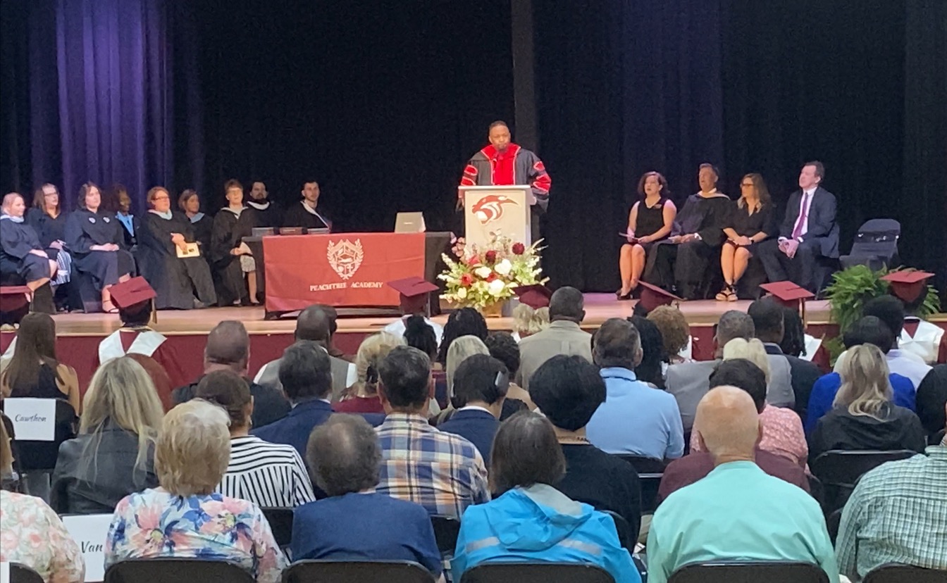 Dr. Demoine Kinney delivering commencement address on stage